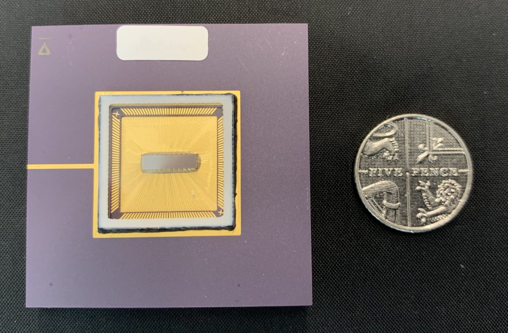 A single‑photon avalanche diode (SPAD) sensor, with a five pence coin for scale.